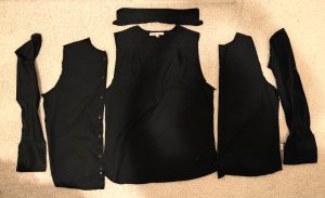 black cotton men's shirt with French cuffs cut along the seams, ready to be upcycled