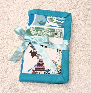 handmade sewn crochet roll, closed in half and tied with a green ribbon