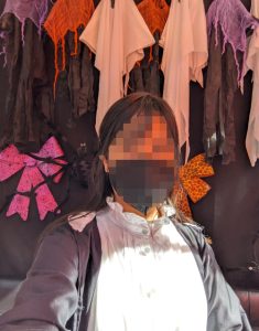 selfie of Fern (Frieren) cosplay against a spooky background with ghosts and spiderwebs