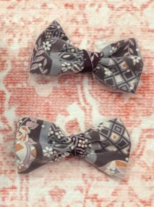 photograph of a pair of bows made of white mesh lace and purple/white/pink kimono print fabric