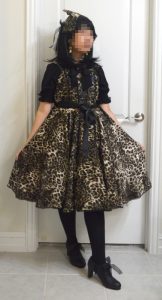 photo of leopard print satin lolita jumperskirt dress with matching hairbow and black/gold jewelry