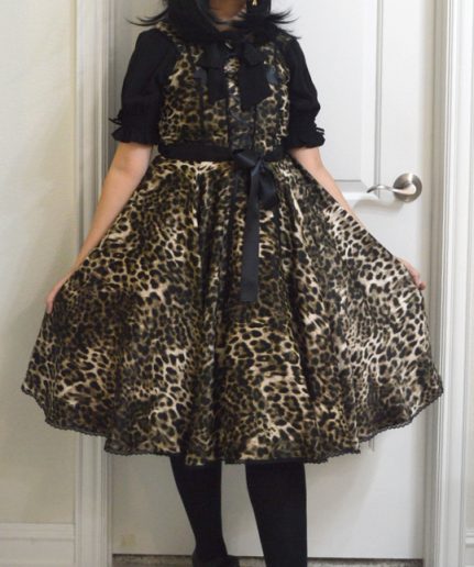 photo of leopard print satin lolita jumperskirt dress with matching hairbow and black/gold jewelry