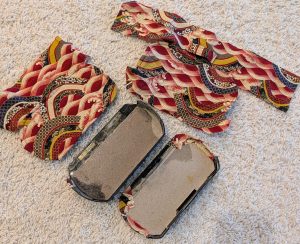 PSP case stripped of the black and repaired, with the top and bottom covers stitched to the side covers