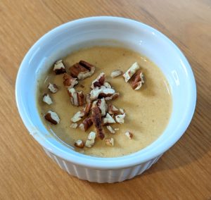 photograph of pumpkin petit pot in a ramekin garnished with pecans