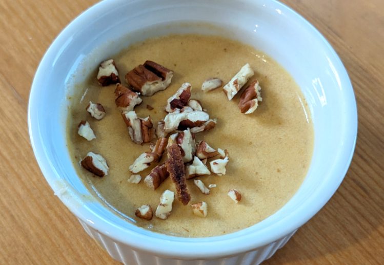photograph of pumpkin petit pot in a ramekin garnished with pecans