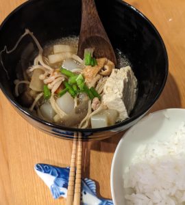 photo of pork/vegetable Japanese soup next to a bowl of white Jasmine rice