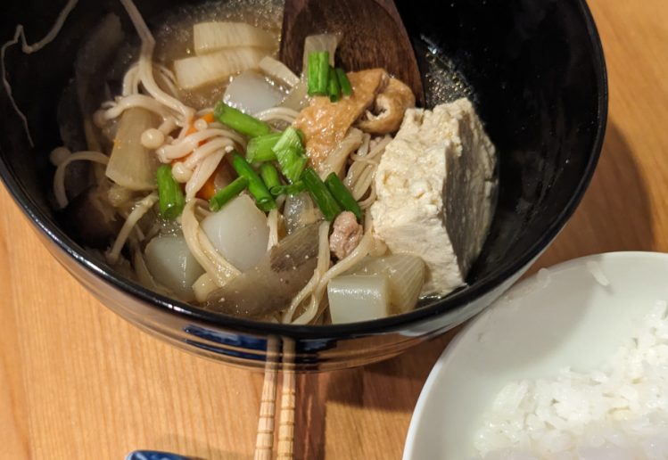 photo of pork/vegetable Japanese soup next to a bowl of white Jasmine rice