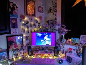 photo of PC setup with pink and purple florals and fanart and official merch of Rei Ryuugazaki (and Rin Matsuoka) from Free! anime