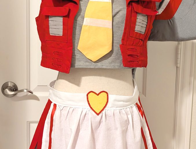photograph of bishoujo Starscream cosplay on a mannequin with a white apron and frilly headdress decorated as a crown