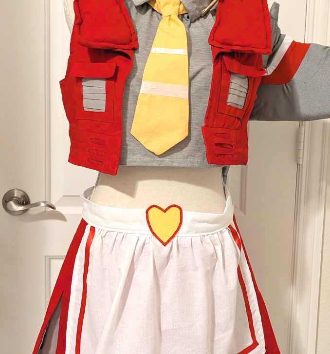 photograph of bishoujo Starscream cosplay on a mannequin with a white apron and frilly headdress decorated as a crown